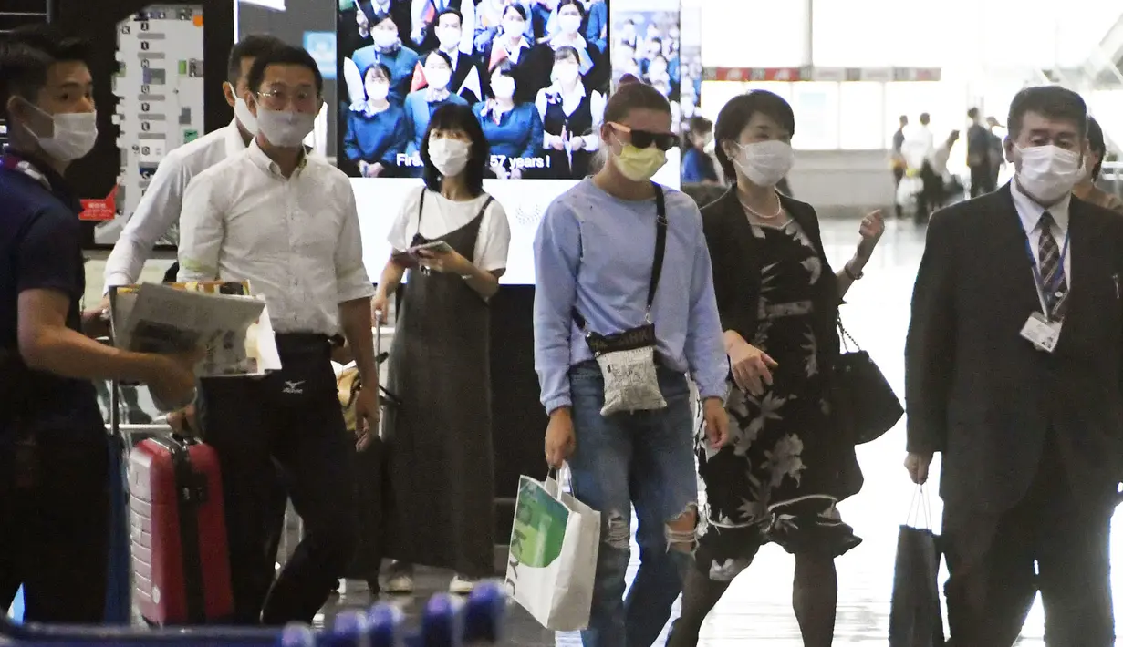 Atlet Olimpiade Belarusia, Krystsina Tsimanouskaya (tengah) tiba di Bandara Narita di Narita, dekat Tokyo, Rabu (4/8/2021). Tsimanouskaya tampil di nomor 100 meter tetapi tidak lolos ke semifinal dan seharusnya tampil di nomor 200 meter, Senin (2/8), namun tidak ikut bertanding. (Kyodo News via AP)