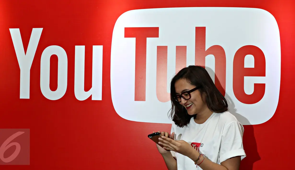 Seorang wanita melintas di depan backdrop YouTube dalam acara yang diselenggarakan YouTube, Jakarta, Selasa (20/10/2015). Menurut Google Indonesia jumlah video yang diunggah pengguna YouTube Indonesia meningkat hingga 600% (Liputan6.com/Immanuel Anton)
