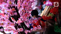Pedagang saat membuat pohon bunga Meihua di salah satu toko Asemka, Glodok, Jakarta, Rabu (3/2/2021). Bunga Meihua ini hanya ada saat perayaan imlek setiap tahunnya. Harga bunga ini dijual dengan kisaran harga mulai Rp200 ribu hingga Rp400 ribu. (Liputan6.com/Johan Tallo)