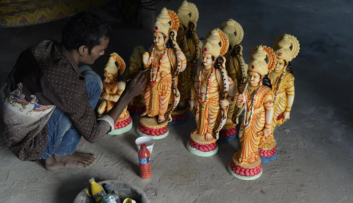 Seorang seniman India mewarnai patung dewa Hindu Rama di sebuah lokakarya di Hyderabad, India (15/3). Umat Hindu India akan merayakan festival Rama Navami yang jatuh pada tanggal 25 Maret. (AFP/Noah Seelam)