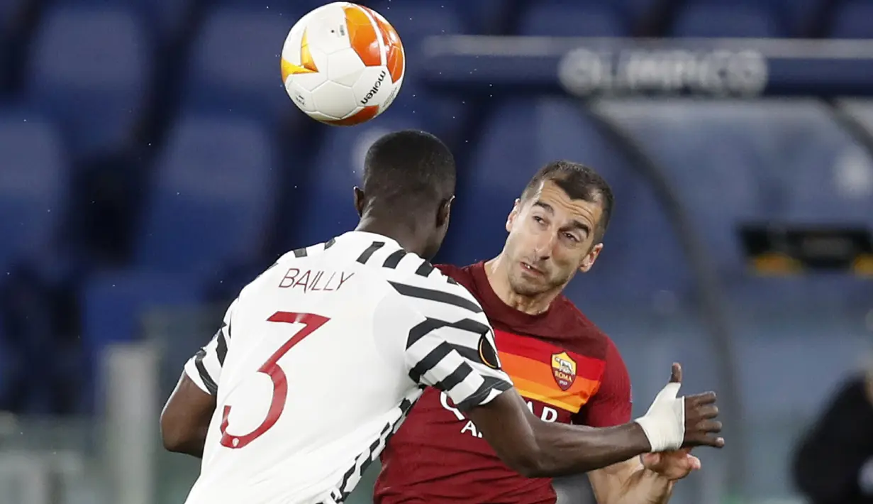 Gelandang AS Roma, Henrikh Mkhitaryan (kanan) berebut bola dengan bek Manchester United, Eric Bailly dalam laga leg kedua semifinal Liga Europa 2020/2021 di Olimpico Stadium, Roma, Kamis (6/5/2021). AS Roma menang 3-2 atas Manchester United. (AP/Alessandra Tarantino)