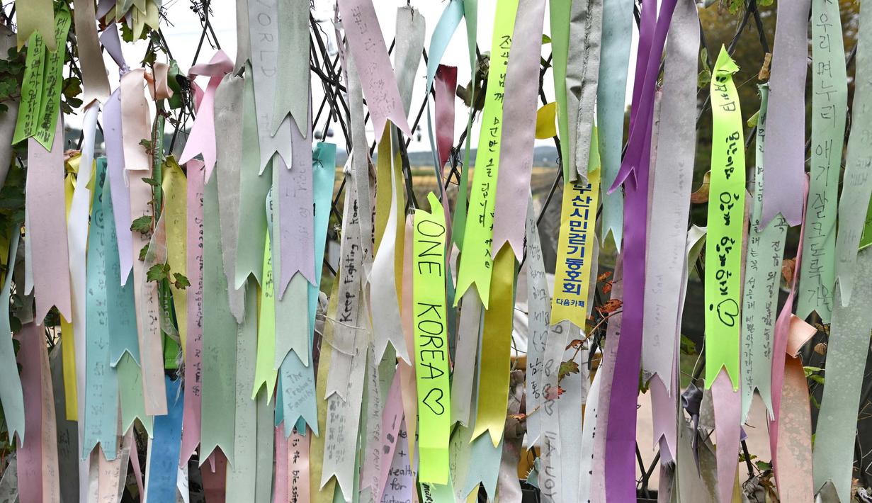 Pita yang mengharapkan perdamaian dan penyatuan kembali Semenanjung Korea digantung di pagar militer di taman perdamaian Imjingak dekat Zona Demiliterisasi (DMZ) yang memisahkan kedua Korea di Paju pada tanggal 14 Oktober 2024. (JUNG YEON-JE/AFP)
