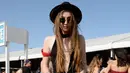 Seorang wanita berpose mengenakan topi dan kacamata hitam saat menghadiri hari pertama Coachella Valley Music and Arts Festival 2016 di Empire Polo Club, California (15/4). Festival ini masuk sebagai festival Musik Terbesar di Dunia. (AFP/Matt Cowan)