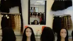 Seorang pekerja menata rambut palsu yang dijual di display centre Raj Hair International, Chennai, India (25/7). India merupakan negara yang telah lama menjadi eksportir rambut palsu terbesar di dunia. (AFP Photo/Arun Sankar)