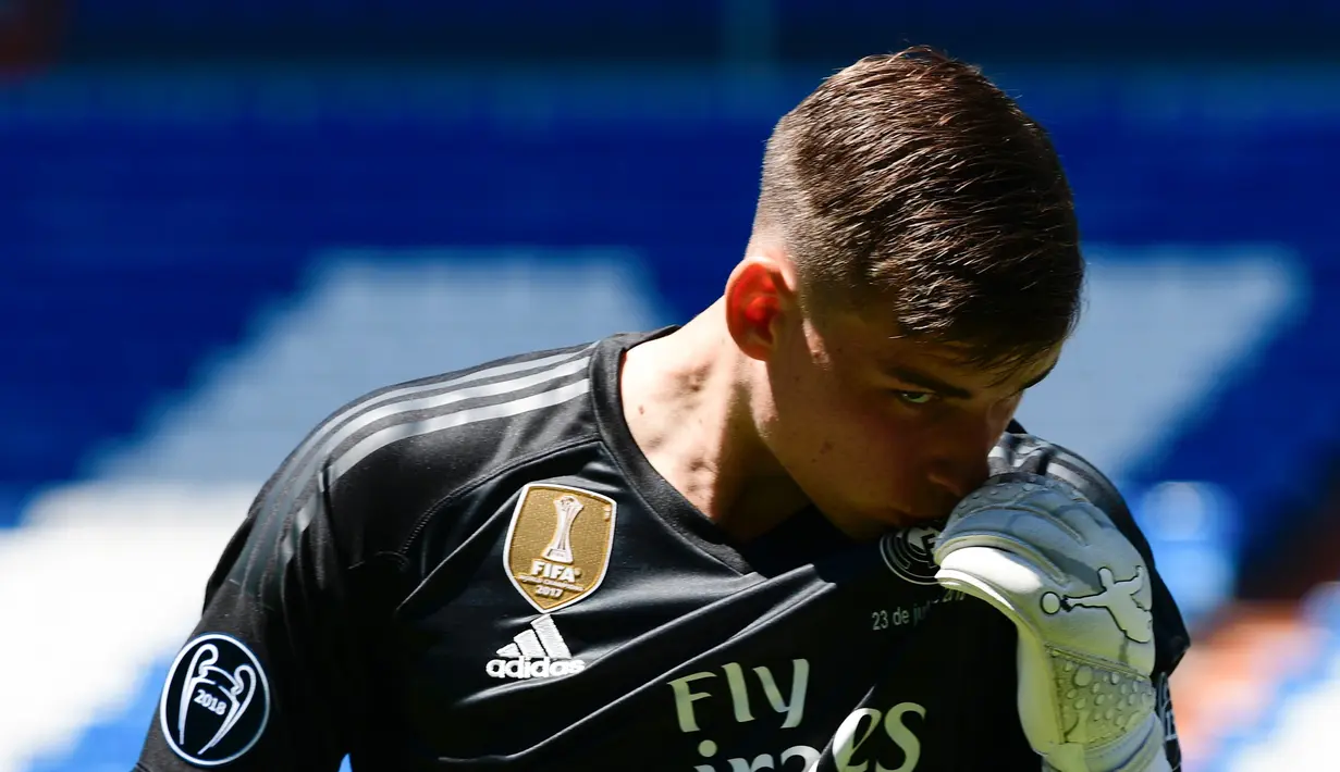 Kiper baru Real Madrid, Andriy Lunin mencium jerseynya saat presentasi di Stadion Santiago Bernabeu, Madrid, Spanyol, Senin (23/7). Andriy Lunin berpostur 191 centimeter. (JAVIER SORIANO/AFP)