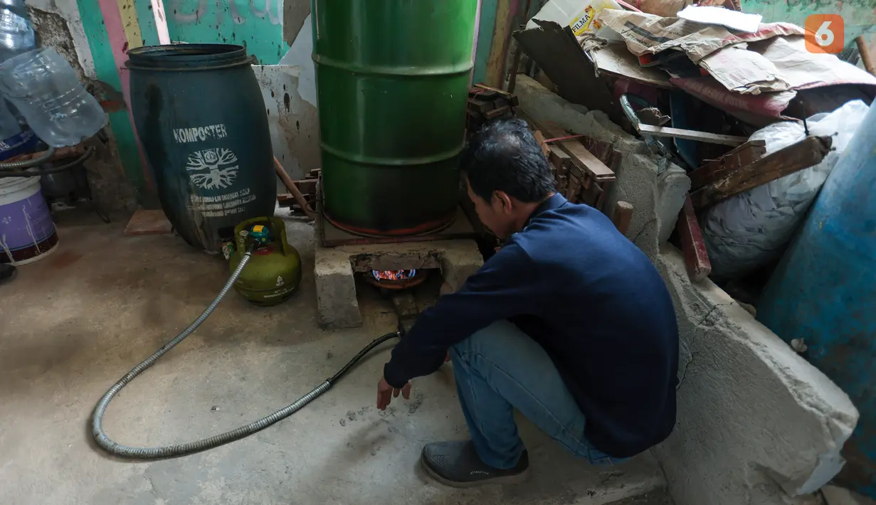 Pengurus RW 01 menyalakan tungku untuk memulai proses pengolahan sampah plastik menjadi bahan bakar alternatif atau petasol di Jakarta, Senin (19/10/2026). Bahan bakar yang dihasilkan dimanfaatkan untuk menunjang kebutuhan operasional pos RW, termasuk kendaraan bermotor. (KLY/Budy Santoso)