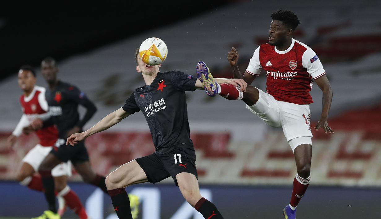 Gelandang Arsenal, Thomas Partey (kanan) berebut bola dengan gelandang Slavia Praha, Lukas Provod dalam laga leg pertama perempatfinal Liga Europa 2020/2021 di Emirates Stadium, London, Kamis (8/4/2021). Arsenal bermain imbang 1-1 dengan Slavia Praha. (AP/Alastair Grant)