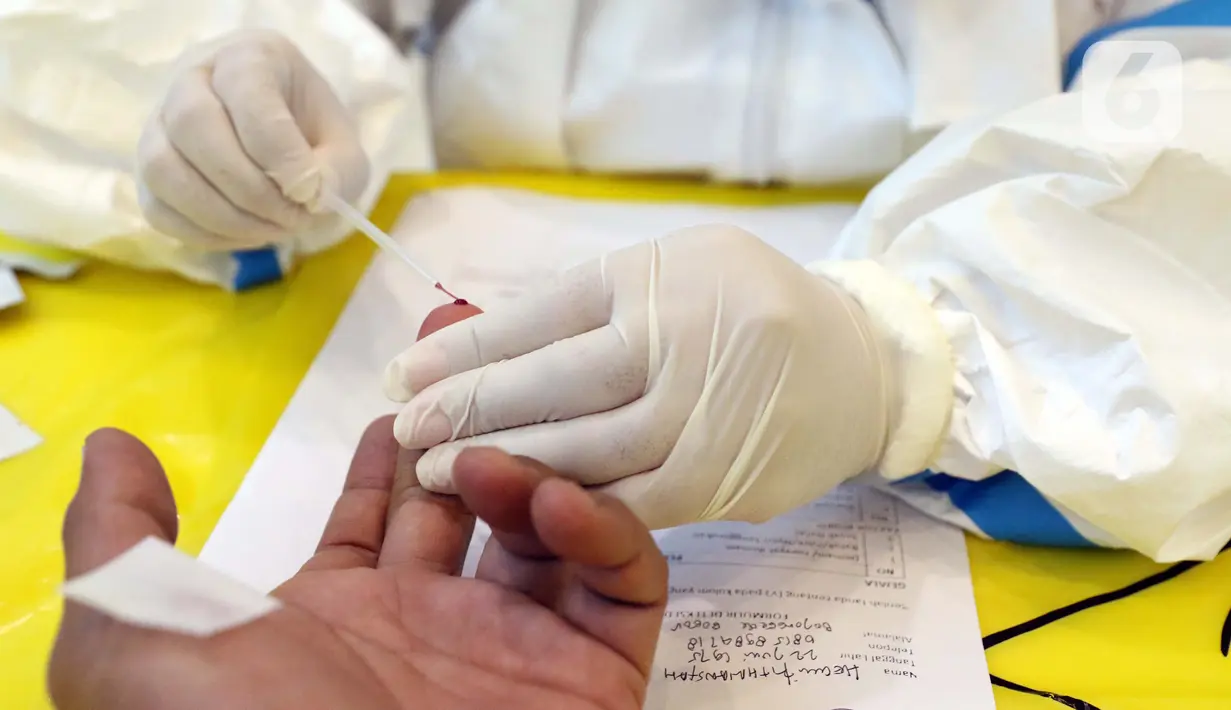 Petugas mengambil sampel darah saat Rapid Test COVID-19 di DPP Partai Golkar, Jakarta, Rabu (8/4/2020). Rapid test memeriksa virus menggunakan antibodi IgG dan IgM yang ada di dalam darah, antibodi akan terbentuk di tubuh saat mengalami infeksi virus. (Liputan6.com/Helmi Fithriansyah)