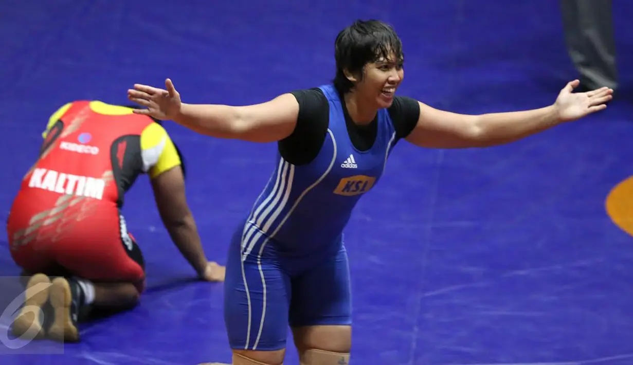 Pegulat putri Kalimantan Selatan Ridha W (biru) mengekspresikan kemenangannya atas Anita (Kaltim) di final gaya bebas kelas 63 kg melawan Anita (Kaltim) pada PON XIX di Arena Saparua Sport Park, Bandung, Sabtu (24/9). (Liputan6.com/Helmi Fithriansyah)