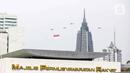 Helikopter TNI AU mengibarkan bendera Merah Putih raksasa di kawasan Gedung DPR RI, Jakarta, Selasa (5/10/2021). Bendera raksasa ini dikibarkan dari timur ke barat langit Jakarta dalam rangka memperingati Hut ke-76 TNI. (Liputan6.com/Faizal Fanani)