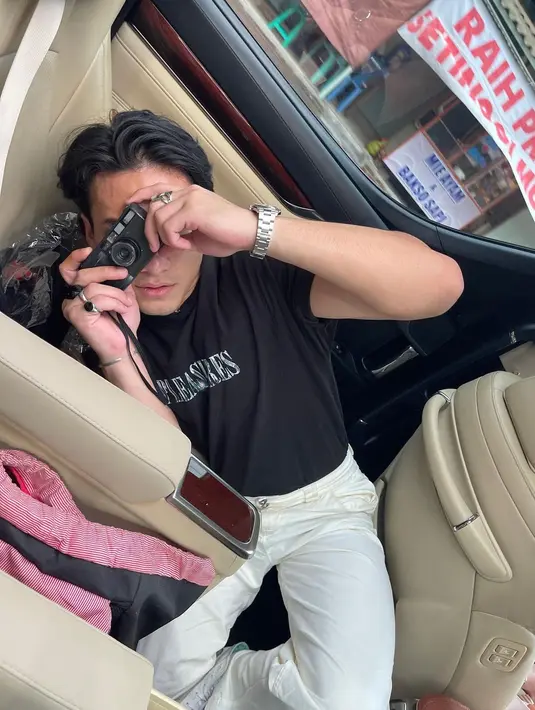 Beginilah polah Pevita Pearce dan Jefri Nichol saat berada di dalam mobil, bergerak dari dan ke lokasi promosi. Tampil santai dengan kaus hitam dan celana putih, Jefri Nichol memegang kamera. Ia siap membidik objek yang tampak di lensa. Kaca jendela mobil memperlihatkan pemandangan pinggir jalan. Salah satunya, warung mi ayam dan bakso. Mampir enggak, nih? (Foto: Dok. Instagram @pevpearce)