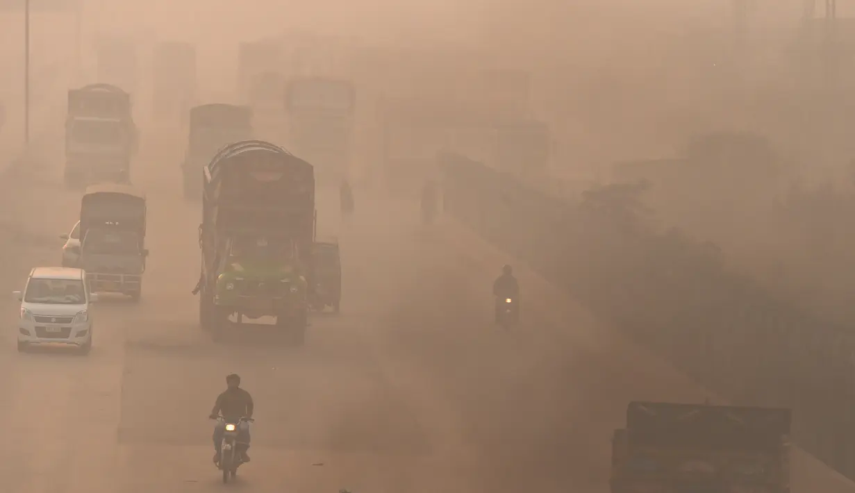 Pengendara kendaraan melintas di tengah kondisi kabut asap di Lahore, Pakistan, Senin (8/11/2021). Lahore menjadi salah satu kota paling tercemar di dunia. (Arif ALI/AFP)