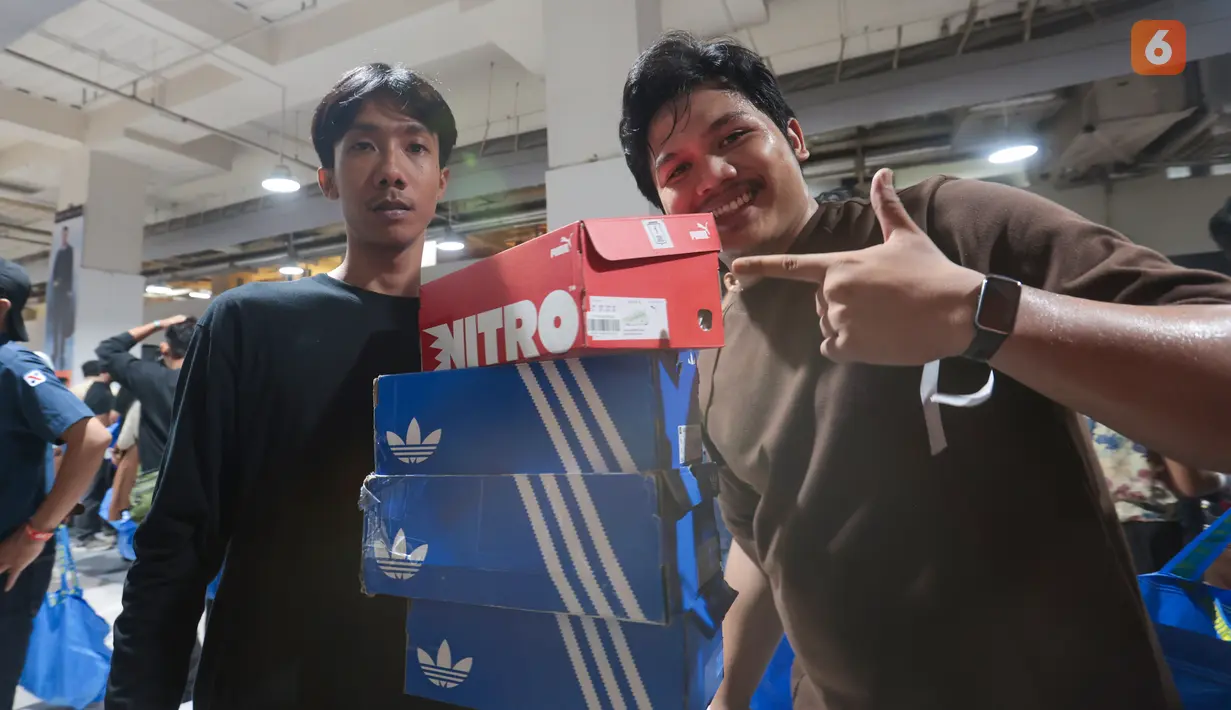 Para jastiper membawa tumpukan sepatu hasil berburu diskon dalam pameran Imperfect Sale 2026 di Blok M Square, Jakarta, Jumat (30/10/2026). Pameran ini menawarkan beragam produk, mulai dari pakaian, tas hingga aksesori dengan harga terjangkau. (KLY/Budy Santoso)