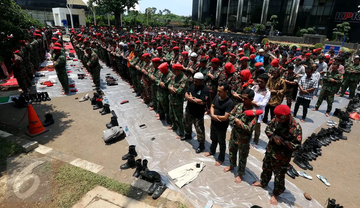 Massa dari Kokam Pemuda Muhammadiyah melaksanakan salat Jumat di depan gedung KPK, Jakarta, Jumat (24/3). Mereka berorasi menyampaikan 3 tuntutan dalam aksi #KawalKPKBerani, salah satunya menuntut penuntasan kasus korupsi e-KTP. (Liputan6.com/Johan Tallo)