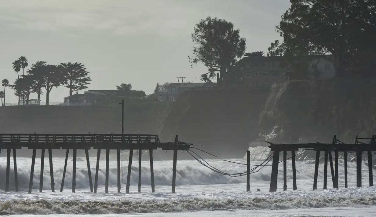 Dermaga Capitola terlihat rusak akibat gelombang badai di Capitola, California, Kamis (5/1/2023). Angin topan yang merusak, ombak bergelombang dan hujan lebat dari "sungai atmosfer" yang kuat menghantam California pada hari Kamis, melumpuhkan listrik hingga puluhan ribu, menyebabkan banjir, dan mengakibatkan kematian setidaknya dua orang, termasuk seorang anak yang rumahnya dihantam pohon tumbang. (AP Photo/Nic Coury)