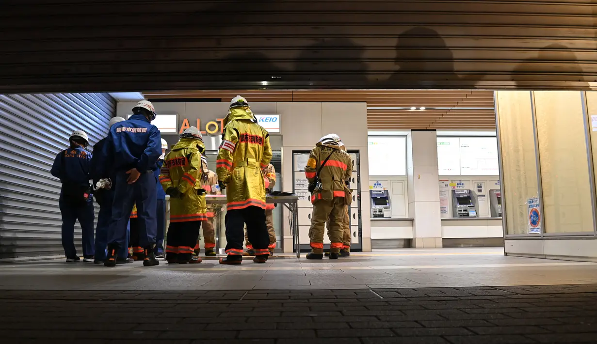 Tim pemadam kebakaran berkumpul di luar Stasiun Kokuryo di Jalur Keio di kota Chofu di Tokyo barat (31/10/2021).  Sang pelaku, kata polisi, berhasil diamankan langsung di tempat kejadian. (AFP/Jiji Press/STR)