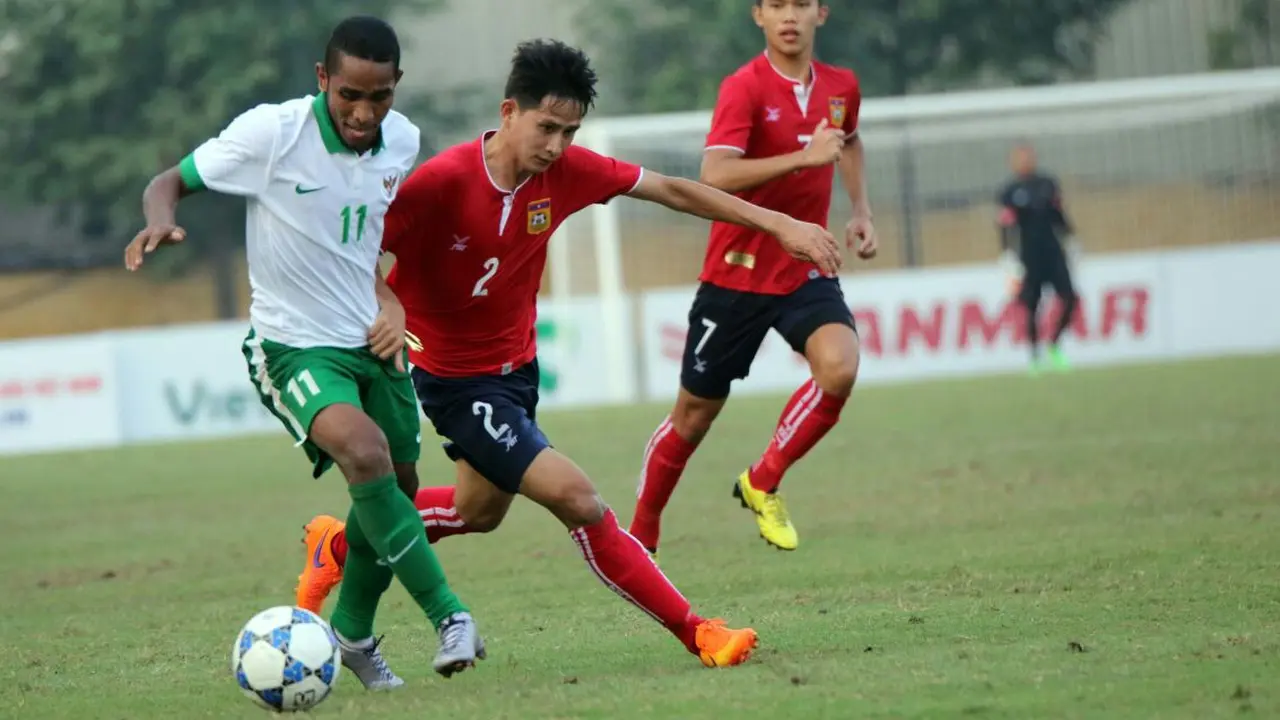Pemain sayap Timnas U-19, Pandi Lestaluhu berebut bola dengan pemain Laos dalam laga yang berakhir dengan skor 3-1 di Vietnam Youth Training Center, Hanoi, Minggu (18/9/2016). (PSSI)