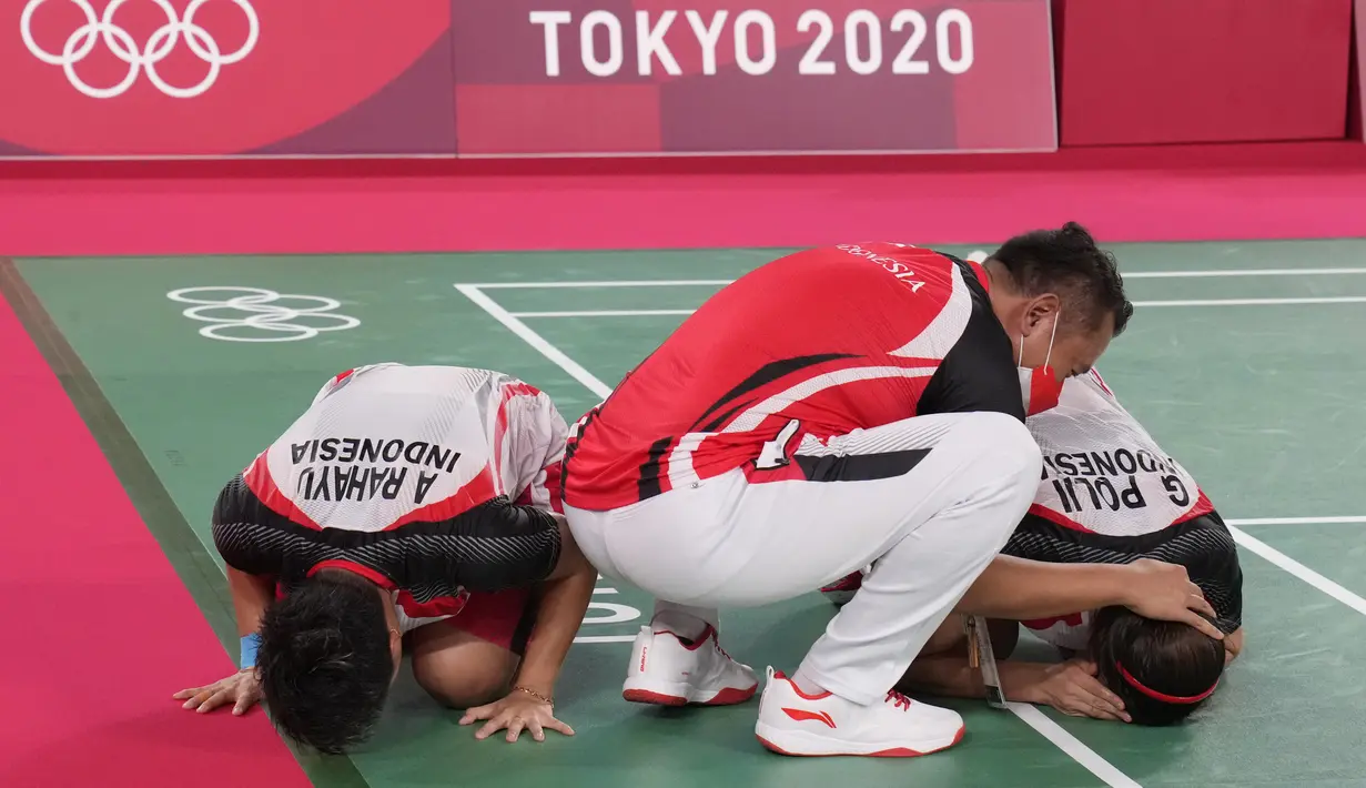 Ganda putri Indonesia Greysia Polii dan Apriyani Rahayu berselebrasi dengan pelatih mereka Eng Hian setelah mengalahkan pasangan China Cheng Qingchen dan Jia Yi pada final badminton ganda putri Olimpiade Tokyo 2020 di Musashino Forest Sport, Senin (2/8/2021). (AP/Dita Alangkara)