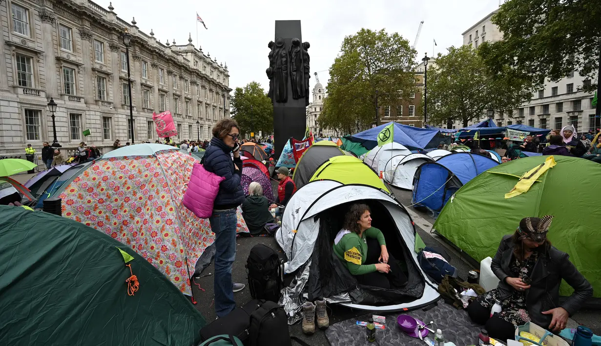 Para aktivis iklim duduk dalam tenda saat mereka berkemah di Westminster, London, Inggris, Selasa (8/10/2019). Protes para aktivis iklim ini telah mengganggu aktivitas warga  kota. (Ben STANSALL/AFP)