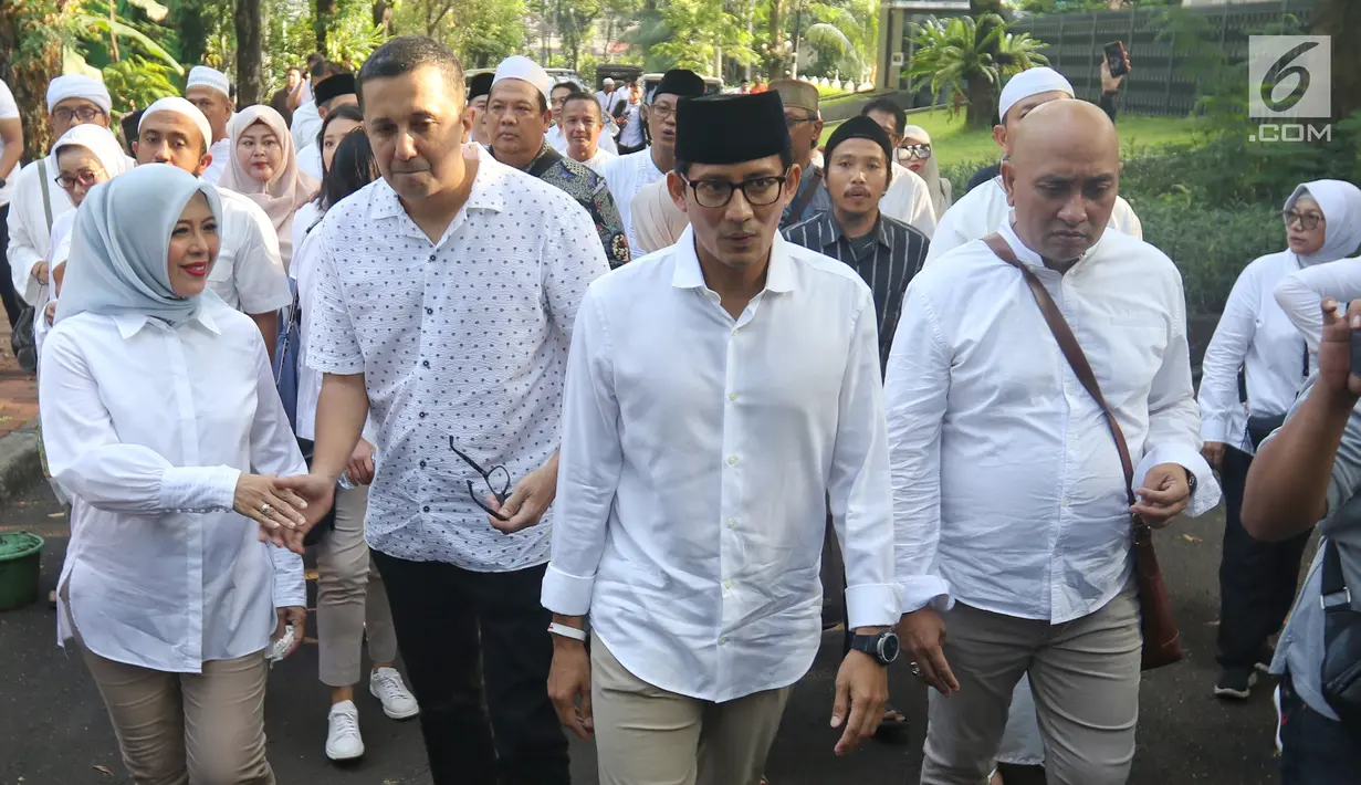 Calon Wakil Presiden nomor urut 02 Sandiaga Uno bersama istri Nur Asia Uno (kiri) menuju TPS 002 Selong untuk menggunakan hak politiknya di Kebayoran Baru, Jakarta Selatan, Rabu (17/4). Pemilu 2019 terdiri dari Pilpres dan Pileg yang diselenggarakan secara serentak. (Liputan6.com/Johan Tallo)