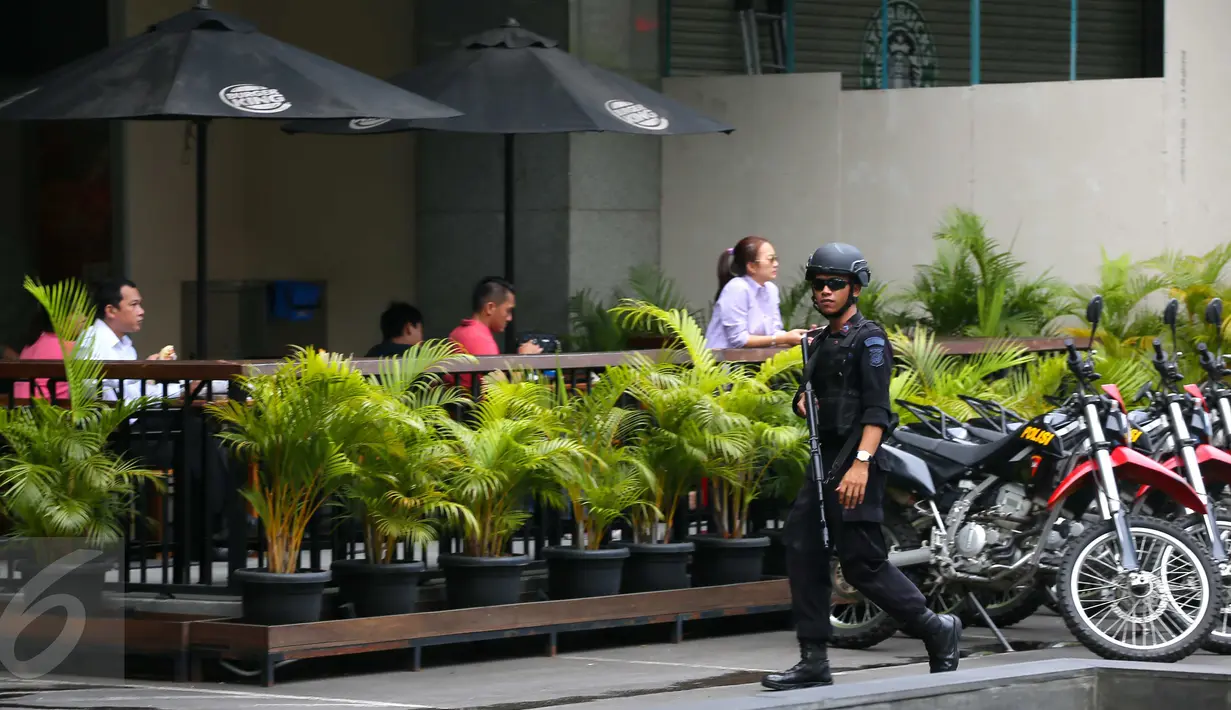 Petugas kepolisian bersenjata terlihat melakukan penjagaan di Menara Cakrawala, Jakarta, Sabtu (16/1). Pasca ledakan di Jalan MH Thamrin pada Kamis (14/1) lalu, petugas keamanan menutup rapat pintu masuk gedung tersebut. (Liputan6.com/Faizal Fanani)