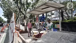 Pekerja menyelesaikan proyek revitalisasi trotoar di Jalan Medan Merdeka Selatan, Jakarta Pusat, Selasa (22/11/2022). Kepala Dinas Bina Marga DKI Jakarta Hari Nugroho mengatakan Rp 171 miliar RAPBD DKI Jakarta 2023 untuk membangun sekitar 20 kilometer trotoar di Ibu Kota. (merdeka.com/Iqbal S. Nugroho)