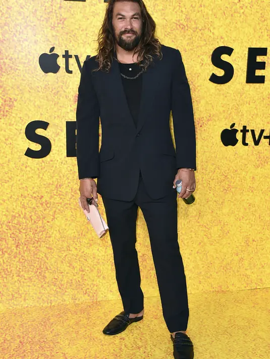 Jason Momoa berpose saat menghadiri pemutaran perdana musim ketiga film "See," di DGA Theater di Los Angeles (23/8/2022). Jason Momoa menjaga gaya busananya tetap klasik. Mantan suami Lisa Bonet ini mengenakan setelan jas hitam dengan sepatu warna senada. (Jordan Strauss/Invision/AP)
