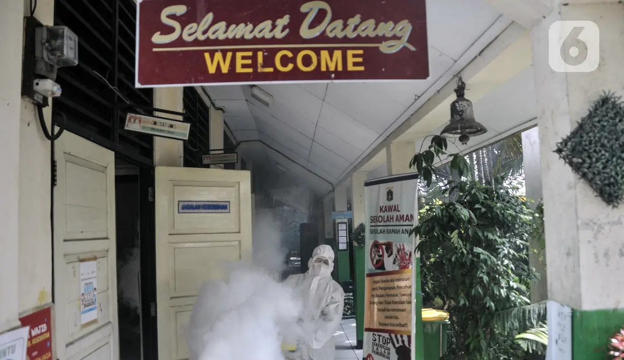 Petugas PMI menyemprotkan disinfektan sebagai upaya pencegahan COVID-19 di SDN Petojo Utara 01, Kecamatan Gambir, Jakarta, Kamis (3/2/2022). Pelaksanaan PTM 100 persen menjadi 50 persen berdasarkan SKB 4 Menteri seiring melonjaknya kasus COVID-19 di lingkungan sekolah. (merdeka.com/Iqbal S. Nugroho)