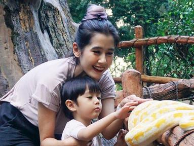 Ardina menunjukkan keberaniannya menyentuh bahkan menggendong ular. Ia juga mengajari sang anak untuk tidak takut. (Instagram.com/ardinarasti6)