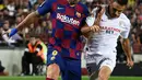 Penyerang Barcelona, Luis Suarez berebut bola dengan bek Sevilla Sergio Reguilon dalam pertandingan pekan kedelapan kompetisi La Liga Spanyol 2019-2020 di Camp Nou, Minggu (6/10/2019). Barcelona berhasil menang telak atas Sevilla dengan skor 4-0. (Josep LAGO / AFP)