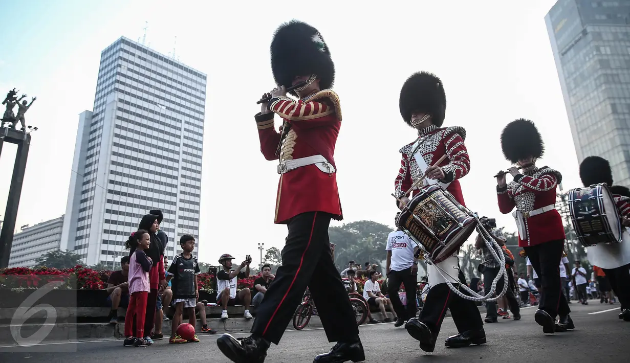 Scotts Guard alias penjaga Buckingham Palace melakukan aksi mengelilingi di Bundaran HI, Jakarta, Minggu (5/6). Aksi Scotts Guard yang didatangkan dari Inggris ini dalam rangka hari ulang tahun Ratu Elizabeth II yang ke-90. (Liputan6.com/Faizal Fanani)