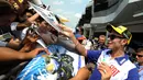 Tanda tangan yang diberikan oleh sang pembalap Valentino Rossi disambut meriah oleh para penggemarnya yang setia menunggu. Tak lupa ia selalu berikan senyuman ramah kepada para penggemar. (AFP/Bintang.com)