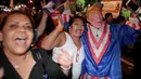 Warga kuba mengenakan kostum berwajah Donald trum saat turun ke jalan merayakan wafatnya Fidel Castro di Miami, AS (26/11). (REUTERS/Javier Galeano)