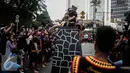 Atraksi seorang pria saat melakukan fahombo atau lompat batu dalam sebuah acara pagelaran seni dan kebudayaan Nias di Jalan Imam Bonjol, Jakarta, Minggu (12/2). Pagelaran ini diselenggarakan oleh Pemuda Peduli Nias. (Liputan6.com/Faizal Fanani)
