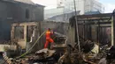 Petugas berusaha memadamkan sisa api yang membakar toko dan pemukiman warga di kawasan Manggarai, Jakarta, Selasa (7/7/2020). Hingga kini belum diketahui pengebab kebakaran. (Liputan6.com/Immanuel Antonius)