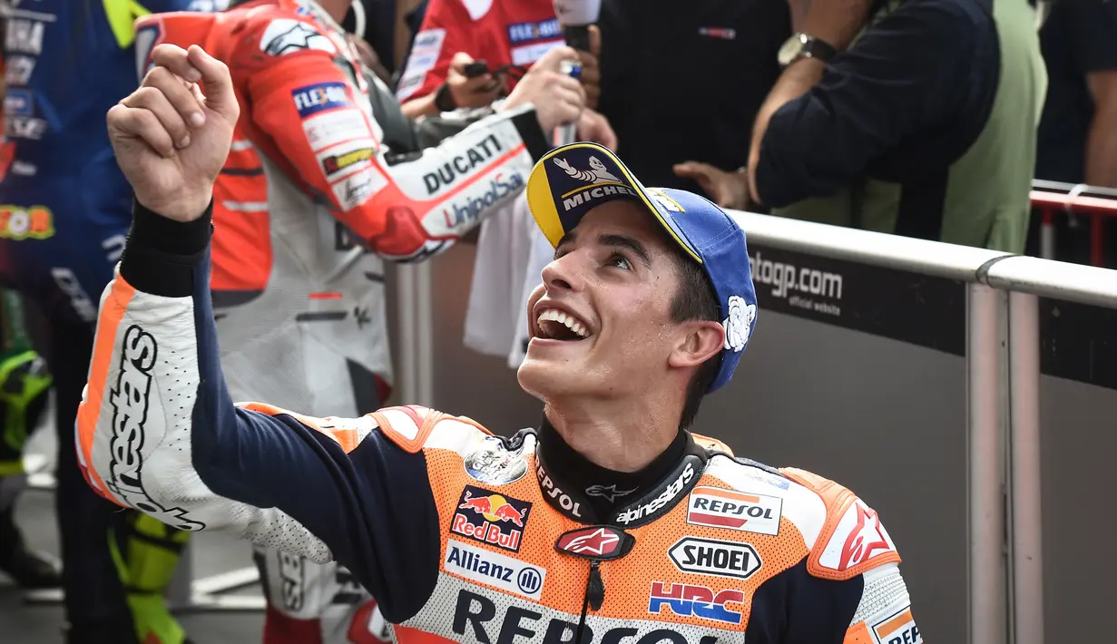 Pebalap tim MotoGP Repsol Honda Marc Marquez tersenyum saat menyapa fans setelah kualifikasi MotoGP Thailand 2018 di Sirkuit Internasional Buriram (6/10). Marquez menorehkan waktu tercepat dengan catatan waktu 1.30.088. (AFP Photo/Lillian Suwanrmpha)