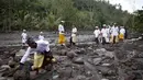 Warga melihat lahar dingin saat akan beribadah di sekitar Sungai Yeh Sah, Desa Batusesa, Kec Rendang, Karangasem, Bali, Jumat (1/12). Warga berharap diberi keselamatan dan berkah dari erupsi Gunung Agung yang terjadi. (Liputan6.com/Immanuel Antonius)