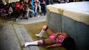 Pegulat wanita Meksiko, Brillo de Luna (kiri) terjatuh dari ring saat tampil di 2 de Junio Arena di Ciudad Nezahualcoyotl, Negara Bagian Meksiko, Minggu (4/2). (Pedro PARDO/AFP)