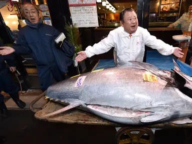 Pengusaha restoran sushi Jepang, Kiyoshi Kimura memamerkan ikan tuna sirip biru seberat 276 kilogram di restoran utamanya di Tokyo, Minggu (5/1/2020). Tuna raksasa itu dibeli dalam lelang perdana 2020 dengan harga USD 1,8 juta atau sekitar Rp 24 miliar. (Kazuhiro NOGI / AFP)