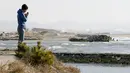 Ko Kimura (38) sedang berdoa menghadap laut untuk mengenang para korban bencana gempa dahsyat dan tsunami besar di Jepang pada 11 Maret 2011 silam, di Higashi - Matsushima, Prefektur Miyagi, Jumat (11/3/2016). (REUTERS / Kyodo)