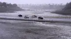 Kendaraan melintasi cekungan pengendali banjir yang hampir mencapai jalan di Palm Desert, California, Minggu, 20 Agustus 2023.(AP Photo/Mark J. Terrill)