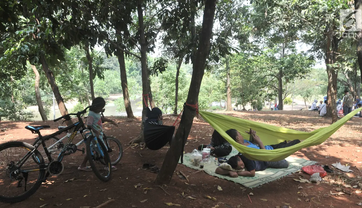 Warga saat bersantai di Taman Cempaka, Cipayung, Jakarta Timur, Minggu (7/7/2019). Taman yang memiliki luas sekitar 64 hektare tersebut menjadi destinasi favorit warga untuk menghabiskan akhir pekan bersama keluarga karena tidak dipungut biaya alias gratis. (merdeka.com/Iqbal S Nugroho)