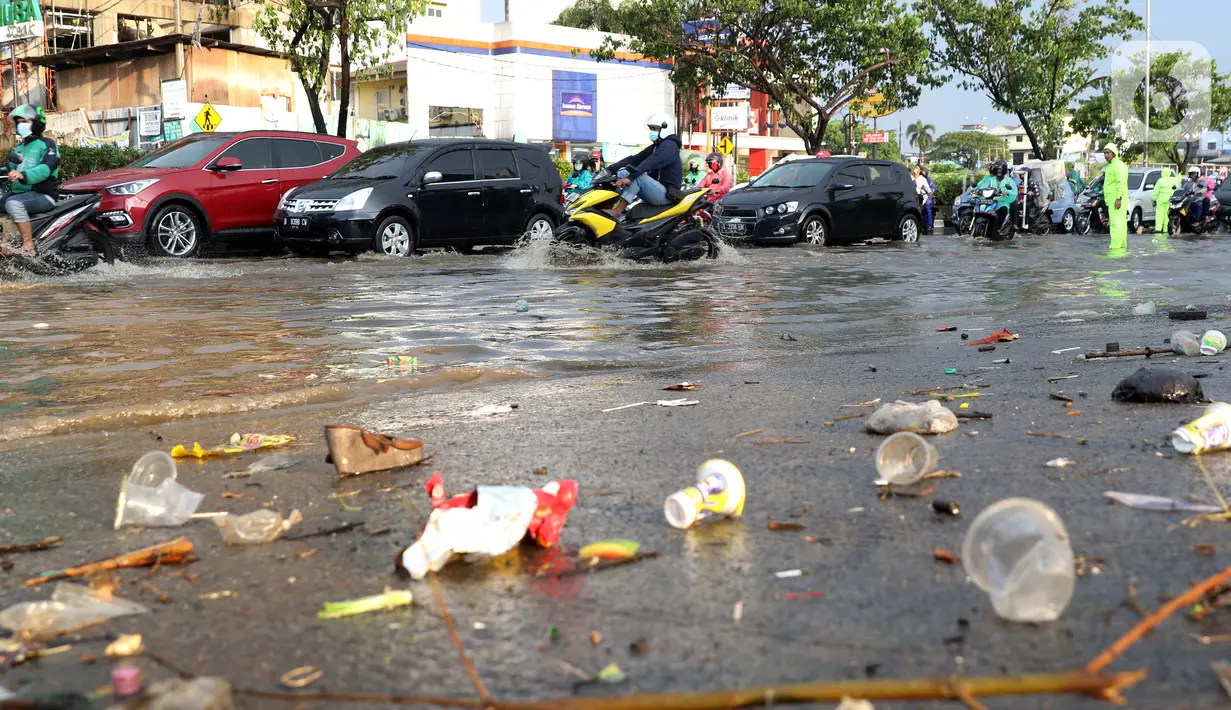 Pengendara melintasi jalan Margonda Raya yang tergenang air, Kota Depok, Jawa Barat, Jumat (29/5/2020). Hujan deras dan tersumbatnya aliran air menyebabkan sebagian ruas jalan Margonda Raya sempat tergenang air serta menyebabkan arus lalu lintas tersendat. (LIputan6.com/Helmi Fithriansyah)