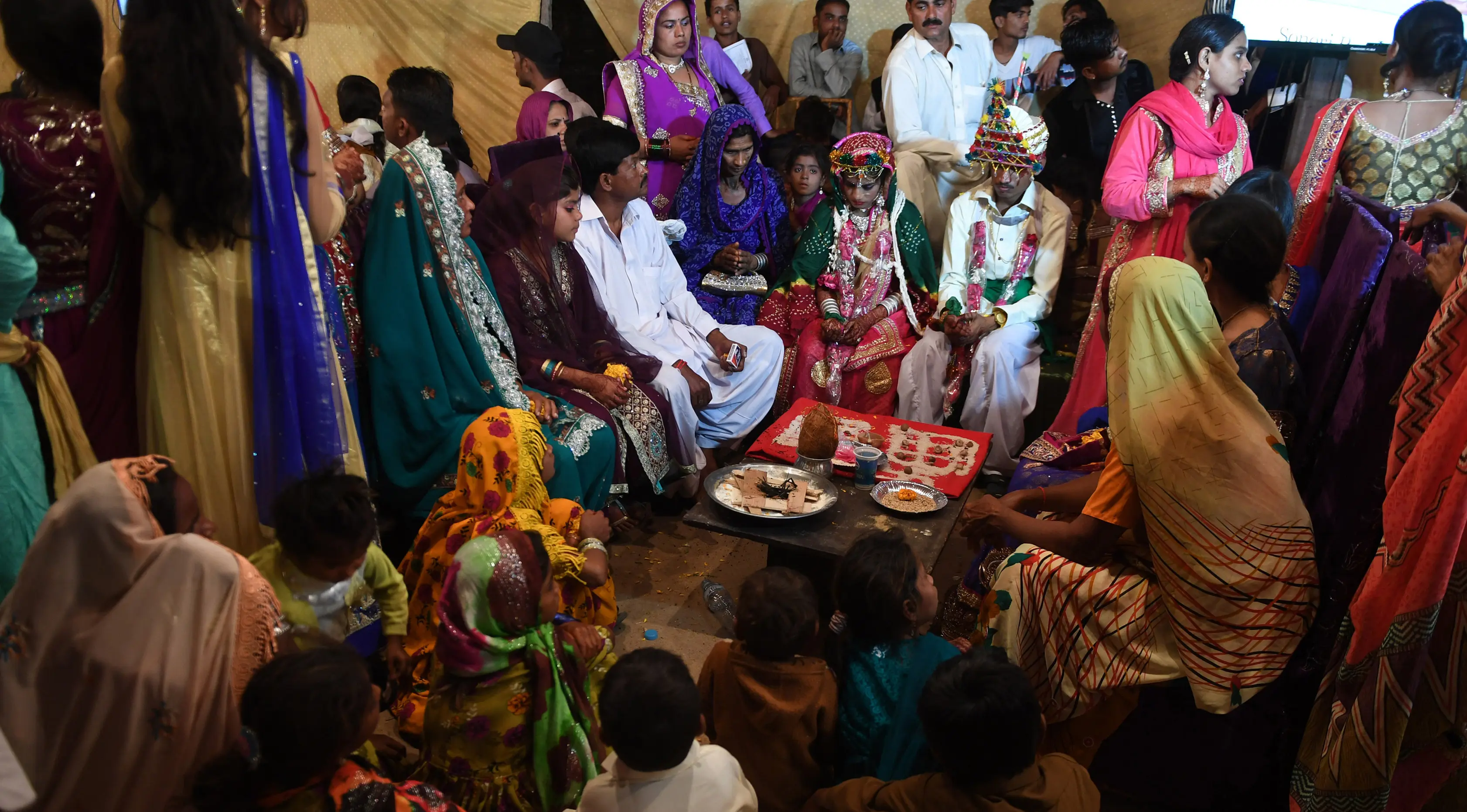 Sejumlah pasangan pengantin menjalani ritual dalam prosesi pernikahan massal umat Hindu di Karachi, Pakistan, (19/3). Sebanyak 62 pasangan pengantin mengikuti pernikahan massal yang merupakan bagian dari perayaan Festival Holi.  (AFP Photo /Asif Hassan)