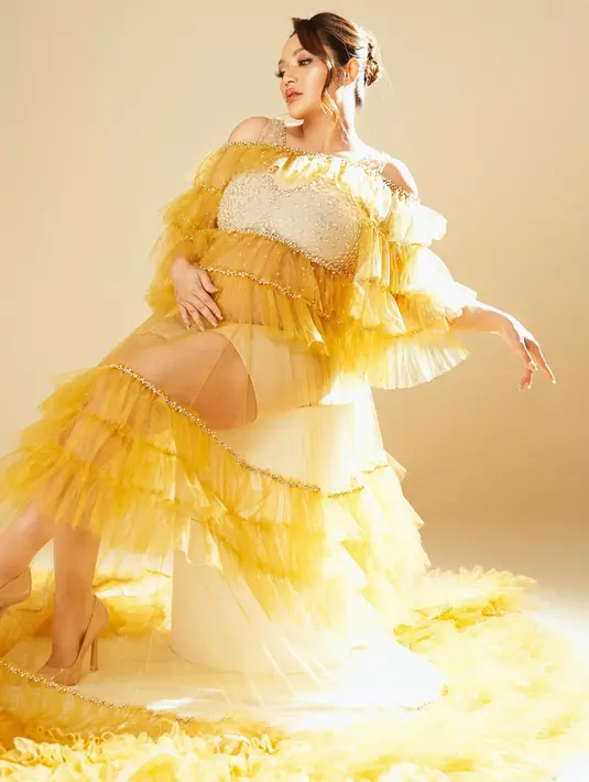 Ia tampil cantik bak Princess Belle dengan gaun off shoulder ruffle kuning karya Yoss Bridal Couture [@sitibadriahh]