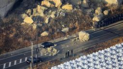 Sebuah batu besar tergeletak di jalan setelah gempa bumi melanda kota, di Soma, prefektur Fukushima, timur laut Jepang, Minggu (14/2/2021).  Sejauh ini belum ada peringatan tsunami. (Hironori Asakawa/Kyodo News via AP)