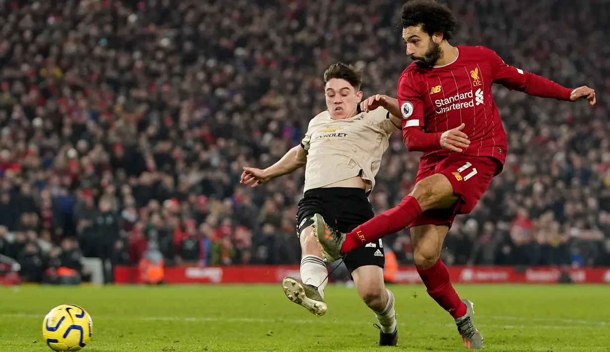 Penyerang Liverpool, Mohamed Salah melepaskan tendangan ke arah gawang Manchester United (MU) untuk mencetak gol pada lanjutan pertandingan Liga Inggris di Anfield, Minggu (19/1/2020). Menghadapi tamunya MU di Anfield, Liverpool menang dengan skor 2-0. (AP/Jon Super)