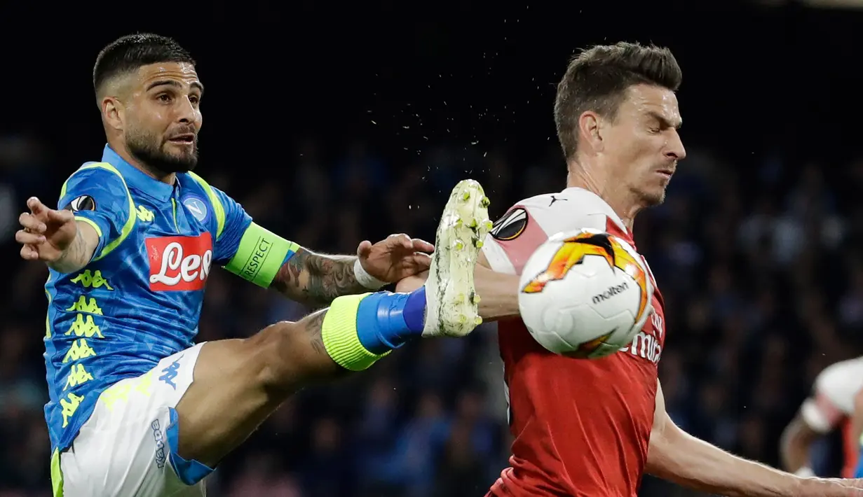 Gelandang Napoli, Lorenzo Insigne berusaha mengontrol bola dari kawalan bek Arsenal, Laurent Koscielny selama pertandingan leg kedua babak perempat final Liga Europa di stadion San Paolo di Naples, Italia (18/4). Arsenal menang agregat 3-0 atas Napoli dan lolos ke semifinal. (AP Photo/Luca Bruno)