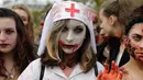 Seorang wanita mengenakan kostum suster bergaya zombie berpose saat mengikuti "Zombie Walk" di Paris, Prancis (7/10). (AFP Photo/Thomas Samson)