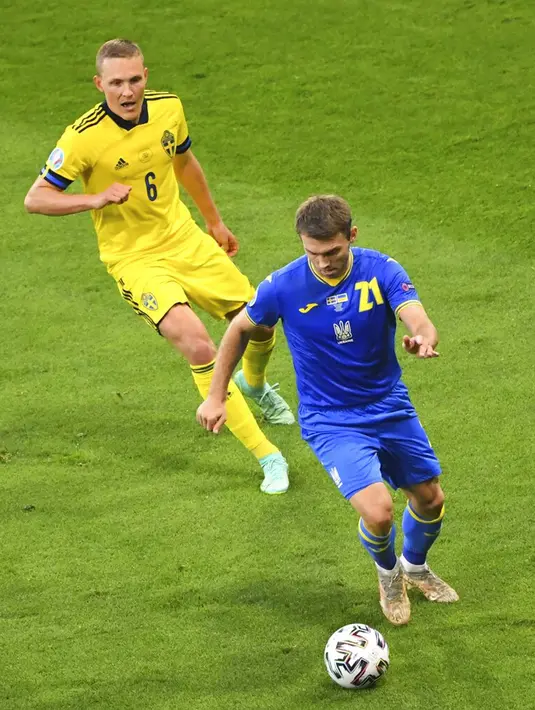 Pemain Ukraina Oleksandr Karavayev (kanan) memperebutkan bola dengan pemain Swedia Ludwig Augustinsson pada pertandingan babak 16 besar Euro 2020 di Stadion Hampden Park, Glasgow, Selasa (29/6/2021). Ukraina menang 2-1. (AP Photo/Andy Buchanan, Pool)